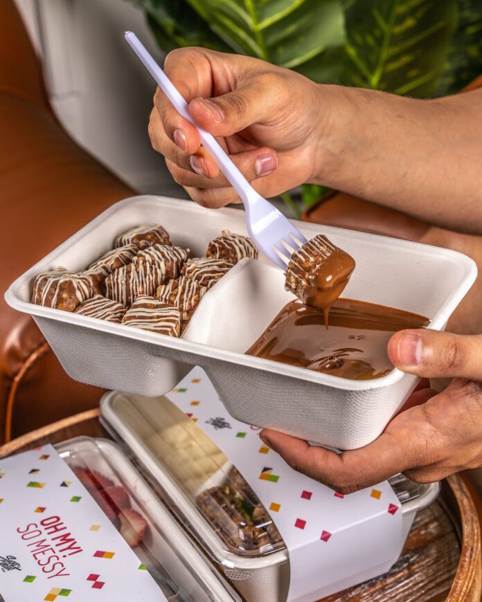 closeup of hands holding a dessert in a plastic container